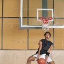 Young man in midair beneath basketball hoop, portrait.jpg 이미지